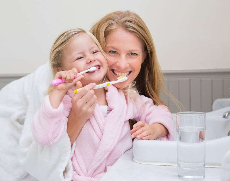 mom and daughter brushing their teeth in coburg hill
