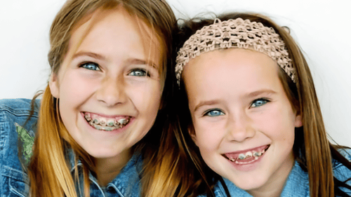 Young girls smiling wearing braces