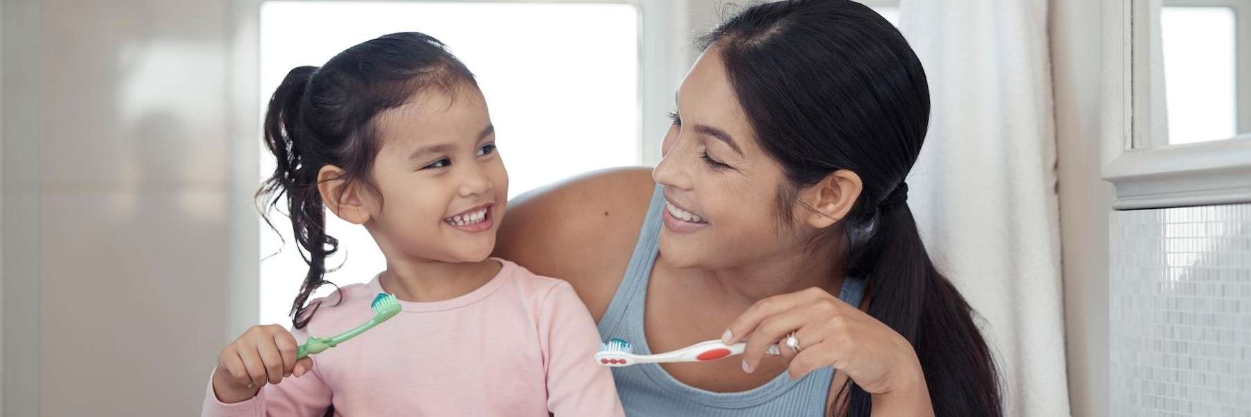 mom showing daughter how to brush teeth in coburg hill